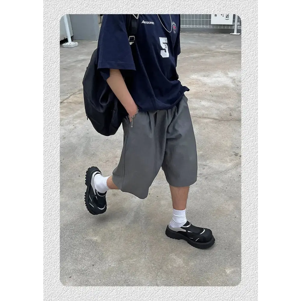Oversized gri şort ve lacivert tişört giymiş Brion erkek tarzı görünüm
