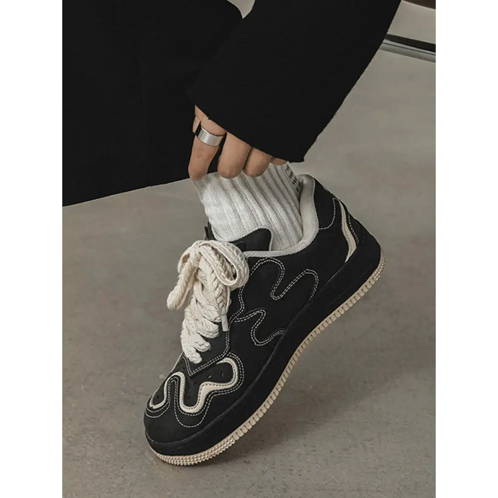 Janor unisex sneakers in black with wavy grey stitching and cream-colored laces