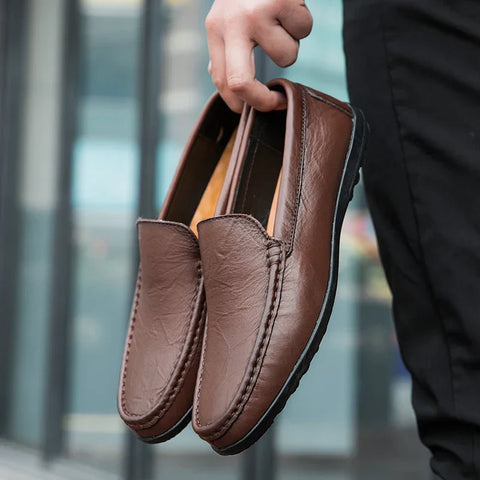 Brown leather loafers held by a hand, ideal for Jardel günlük ayakkabı koleksiyonu