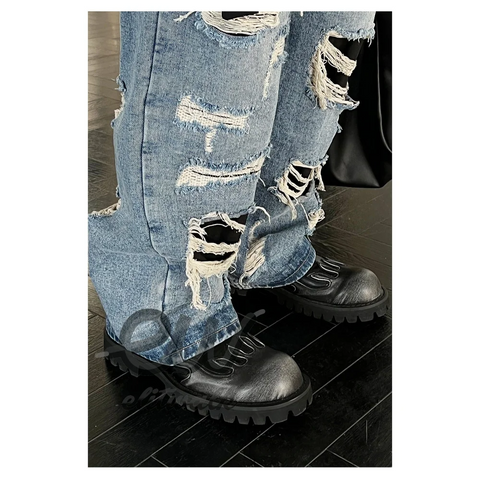 Heavily distressed blue jeans styled with Jardis siyah unisex bot for a trendy look